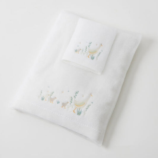 A white cotton baby bath towel with green and beige duck embroidery, presented neatly folded.